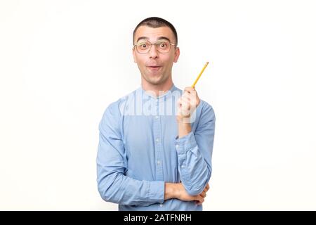Young hispanic man in glasses is thinking about something with pencil generating idea. Studio shot Stock Photo