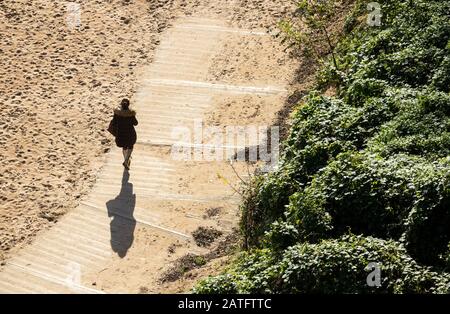 Woman walking on beach boardwalk Stock Photo