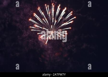 Beautiful inexpensive red fireworks against the dark sky. With smoke. Stock Photo