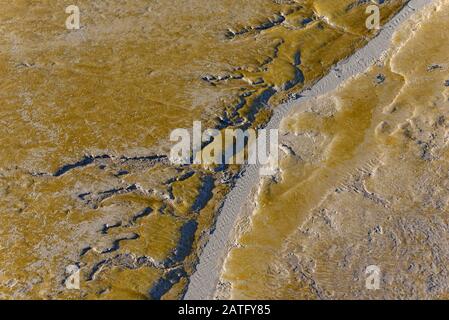 The mud, exposed at low tide, in Watchet harbour, Somerset, UK, looks like a satellite image of an unknown land Stock Photo