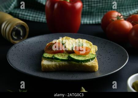 Delicious sandwiches with potatoes, cucumbers and tomatoes on grey plate close-up. Stock Photo
