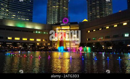 Multi-colored dancing fountains near the twin towers of Petronas in Kuala Lumpur. Stock Photo