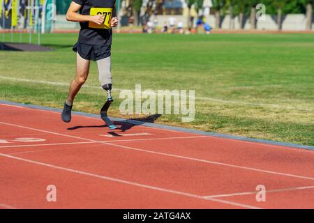 Amputee athlete running on a stadium track Stock Photo