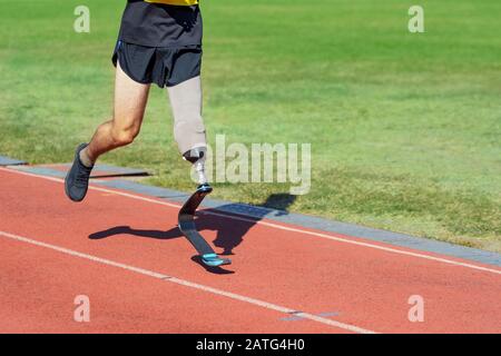 Amputee athlete running on a track at the stadium Stock Photo