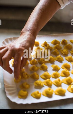Italian woman making homemade tortellini Stock Photo