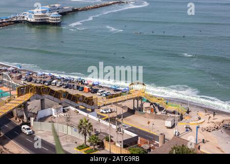 MIRAFLORES, LIMA, PERU - May 10, 2016: A variety of vendors and shops renting surf gear on the Pacific beach next to the Nautical Rose restaraunt in M Stock Photo