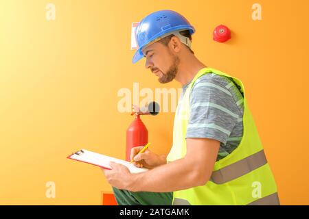 Fire safety specialist inspecting extinguisher Stock Photo