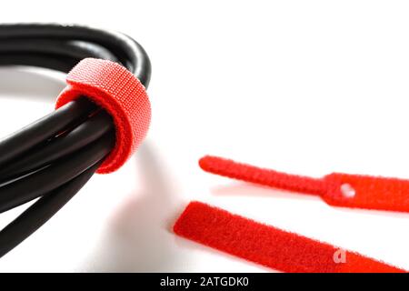 red velcro cable tie and cable on white Stock Photo