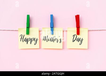 Happy Mother's Day greeting text on hanging paper note. Pink background. Stock Photo
