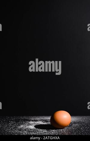 Close up view of the organic brown raw chicken egg isolated on the black background. Stock Photo
