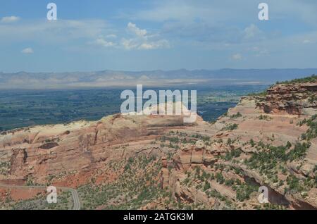 Summer in Colorado National Monument: Looking Across Rim Rock Drive and Fruita Canyon to Grand Valley and the Book Cliffs from Fruita Canyon View Stock Photo