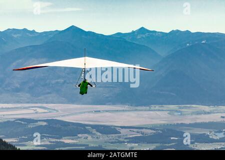 Hand gliding flight over farmlands and mountains of Kootenay valley, Creston, British Columbia, Canada. Fly to your dreams Stock Photo