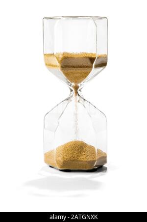 Sand running through an hourglass with shadow measuring passing time and counting down to a deadline isolated on white Stock Photo