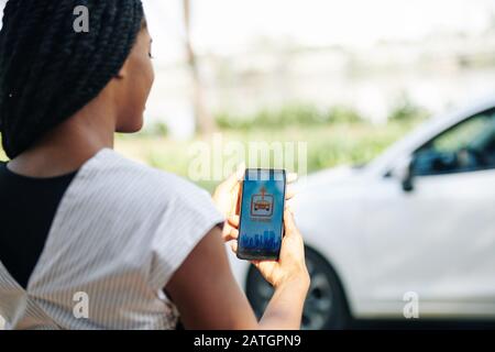 Young woman using car sharing application when getting to work in the morning Stock Photo