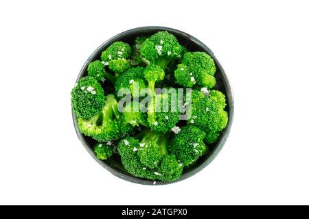 A bowl of cooked broccoli, isolated on a white background with a clipping path, shot from above with salt Stock Photo