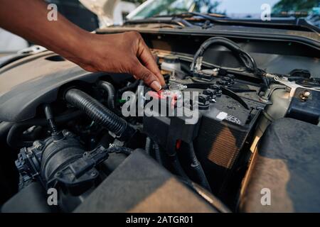 Close-up image of woman checking or changing car battery Stock Photo