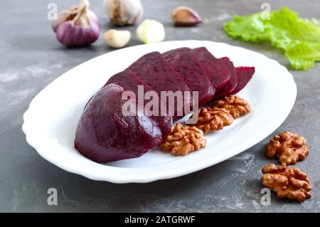 Slices of boiled beets on a white plate. Source of energy. Dietary healthy vegetable. Stock Photo