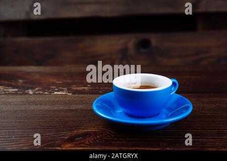 Dirty blue cup after coffee on a wooden table.  Stock Photo