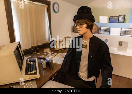 Typical office workspace in the 1980s with first vintage PC. Female mannequin in casual clothing of the 80s. A wax figure of office secretary Stock Photo