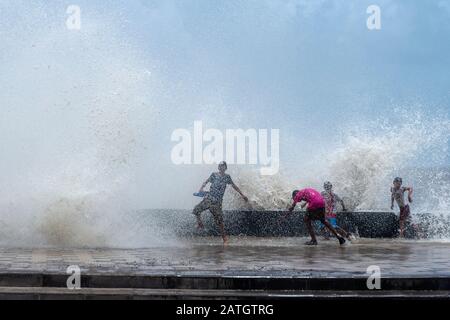 Worli sea face, Kids enjoying the water spray caused by waves breaking, Mumbai, India Stock Photo