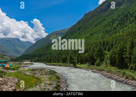 Tents by side of Glacier River through Chitkul Village, Himachal Pradesh, India Stock Photo