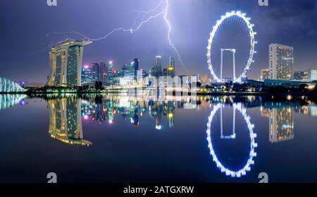 Singapore at night with storm and lightning bolt Stock Photo