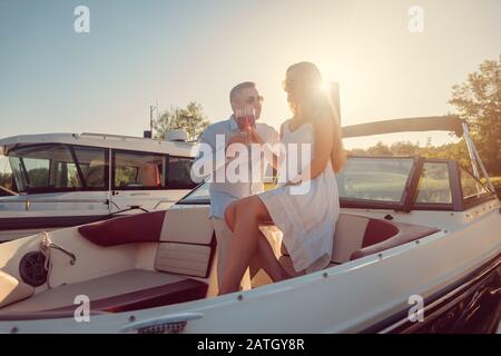 Couple in a river boat or yacht toasting with sparkling wine Stock Photo