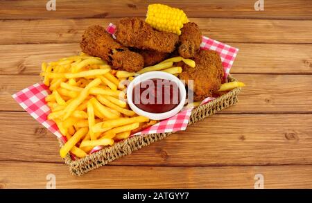 Southern fried chicken and French fries meal in a basket on a wood background Stock Photo