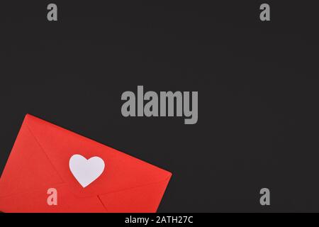 Valentine background with red love letter with white heart at bottom and blank black copy space Stock Photo