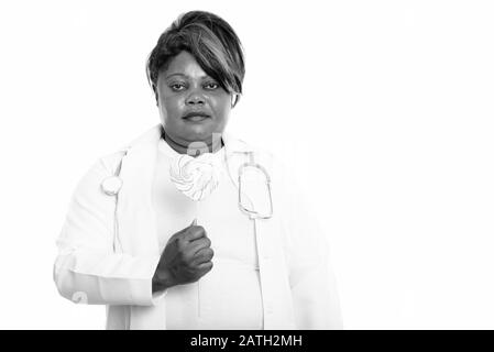 Studio shot of fat black African woman doctor holding heart shaped lollipop