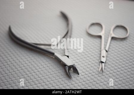 Set of tools for manicure on the table, cuticle nippers and scissors on a white towel Stock Photo