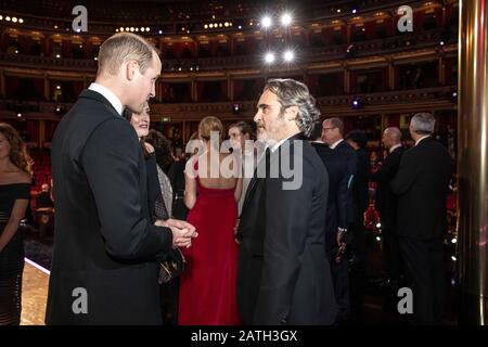 Prince William taels with Joaquin Phoenix after the ceremony on stage at the The British Academy Film Awards at the Royal Albert Hall, London, UK Stock Photo