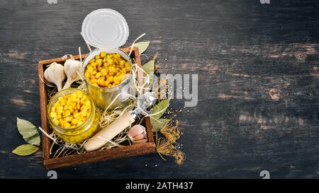 Pickled corn in a jar. Stocks of food. Top view. On a wooden background. Copy space Stock Photo