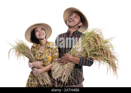 young asian couple farmer looking up to copy space while holding rice grain together Stock Photo