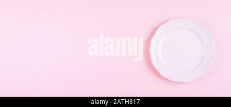 Light pink empty plate on pink table background. Kitchen dish. Recipe Menu Concept. Banner for website. Top view, flat lay, copy space Stock Photo