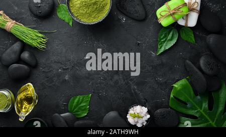 Zen stones and leaves with water drops. Spa background with spa accessories on a dark background. Top view. Free space for your text. Stock Photo