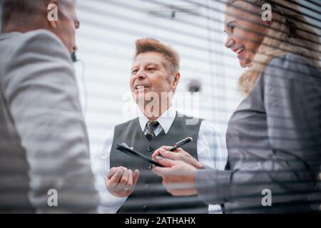 close up. a group of serious employees discuss something standing in the office. Stock Photo