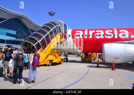 Passengers, including tourists, go up mobile steps to board an Air Asia plane at Cam Ranh International Airport, Vietnam, Asia Stock Photo