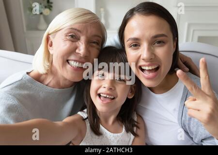Overjoyed three generations of women take selfie together Stock Photo