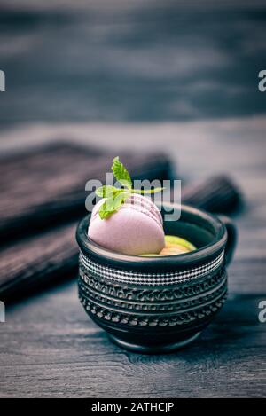 Homemade french violet lavender macaroon or macaron in a black cup on dark background Stock Photo
