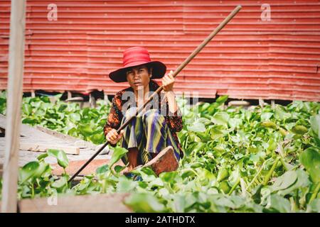 Puok, Siem Reap Province, Cambodia - 4 April 2013: Cambodian woman in canoe with paddle in Tonle Sap lake Stock Photo