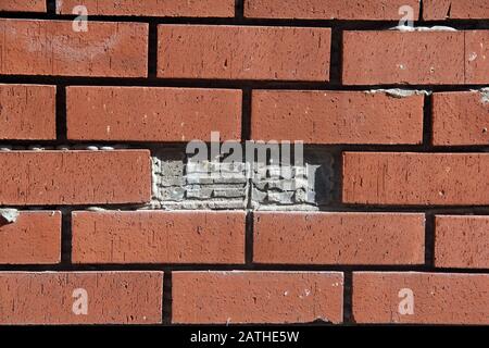 Garden wall with missing a brick Stock Photo