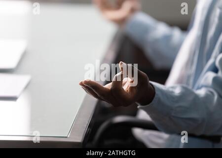African worker man meditating closeup focus on folded fingers gesture Stock Photo