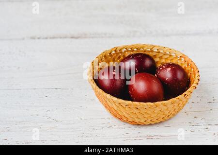Old fashioned colored easter eggs in straw basket Stock Photo