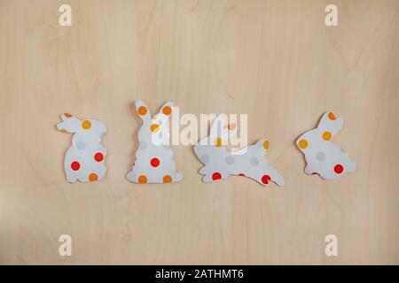 Paper silhouettes of an easter bunnys on wooden background Stock Photo