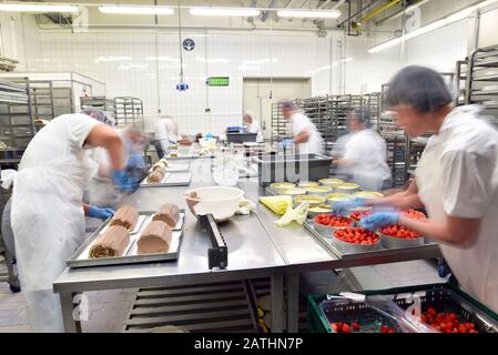Worker in a large bakery - industrial production of bakery products on an assembly line Stock Photo