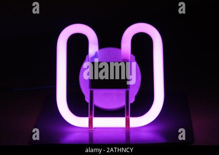 Coloured compact fluorescent lamp with dark background Stock Photo