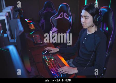High angle portrait of young Asian man playing video games in cyber sports chair, copy space Stock Photo
