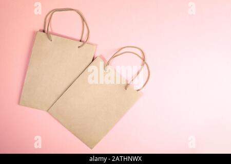 Blank mockup with two paper bags on pink background. Zero Waste holiday, shopping or sale concept. Close-up, top view, flat lay, copy space. Stock Photo