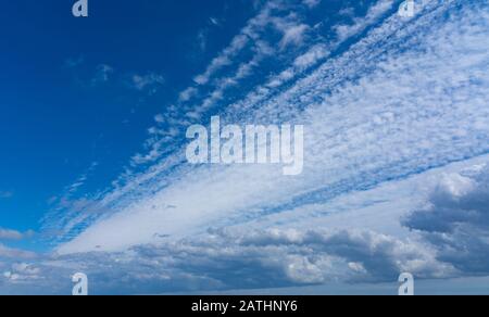Wispy white cloud formation against a vibrant blue sky. Perry Green, Much Hadham, Hertfordshire. UK Stock Photo